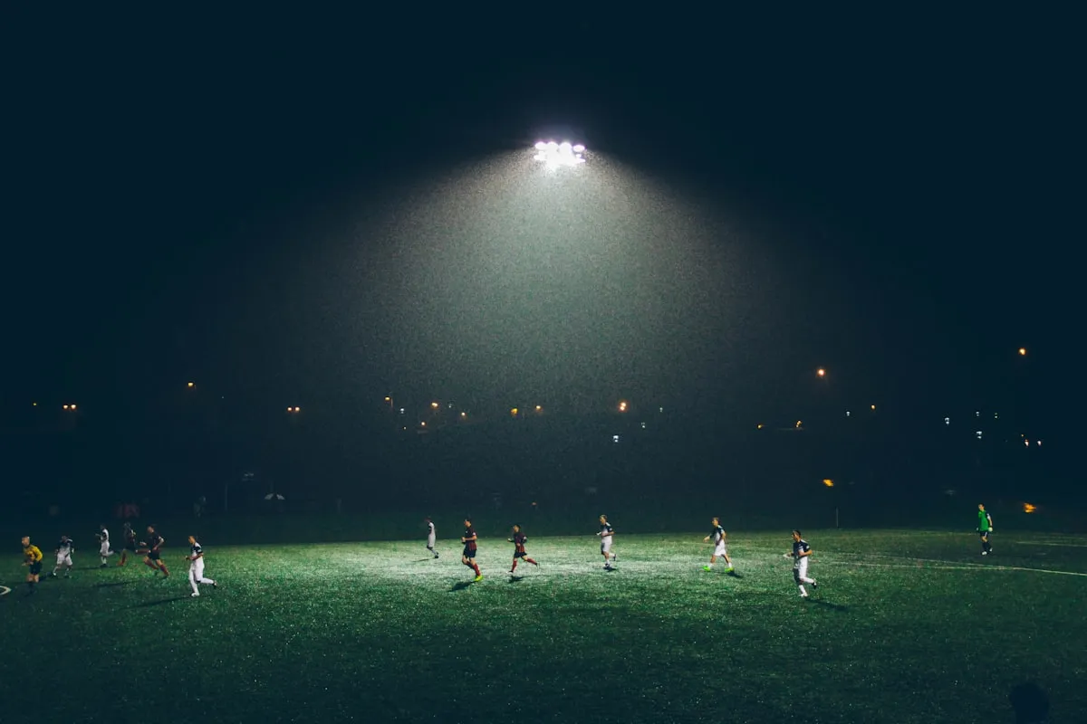 Five-a-side football match under floodlights at night