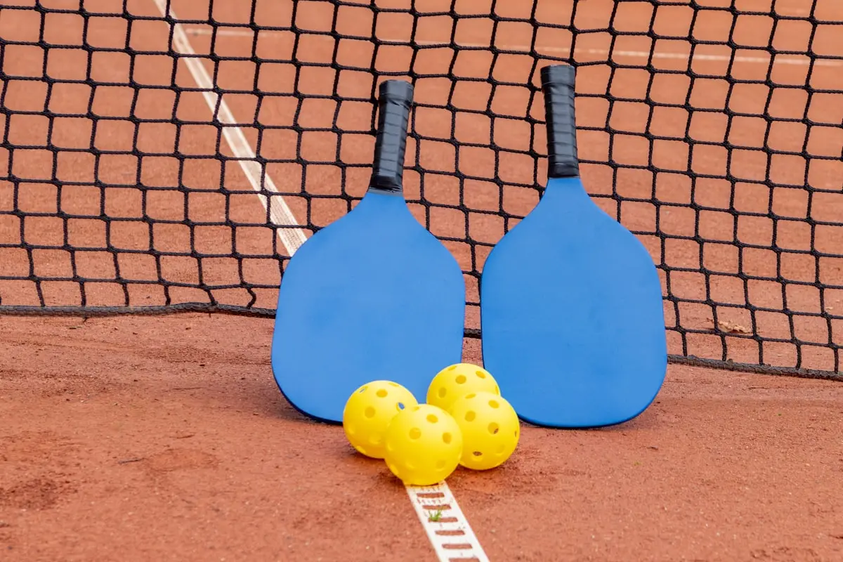 Pickleball paddles and balls by the net